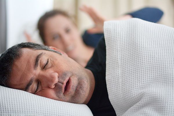 Man snoring next to woman